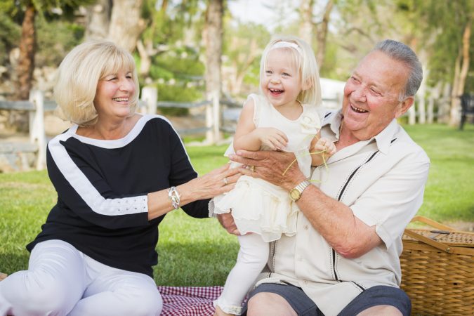 Affectionate Granddaughter and Grandparents Playing Outside At The Park.